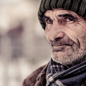 Elderly man wearing woollen hat and scarf