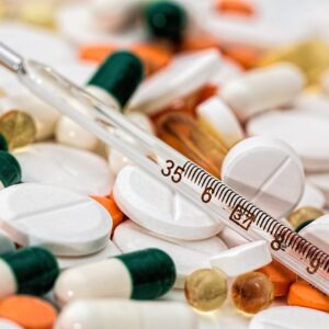 assorted pills with thermometer on top